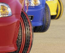 parked cars close-up showing colour stripped tyre tread with steering turned outward sharply