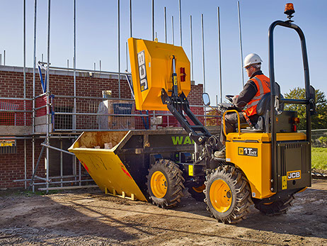 building construction scene with labourer sitting in bright yellow j c b digger